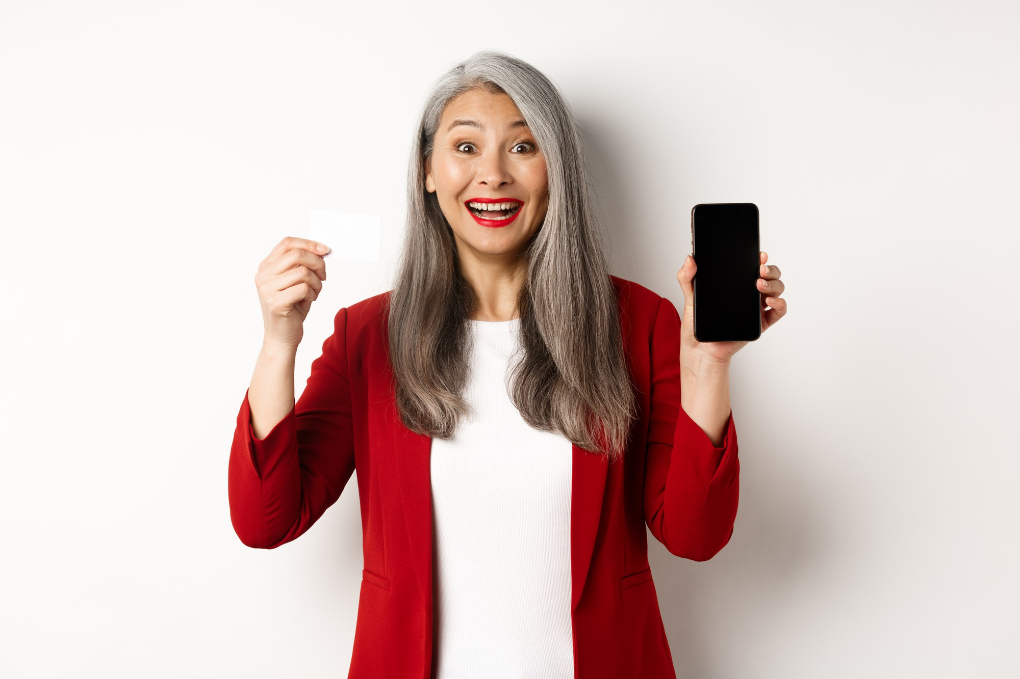 Une femme senior utilise son smartphone en toute simplicité : avec les forfaits mobiles adaptés